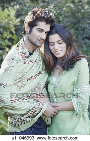 Stock Image - Close-up of a young couple standing in the garden. Fotosearch