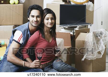 Stock Image - Portrait of a young couple holding wineglasses. Fotosearch