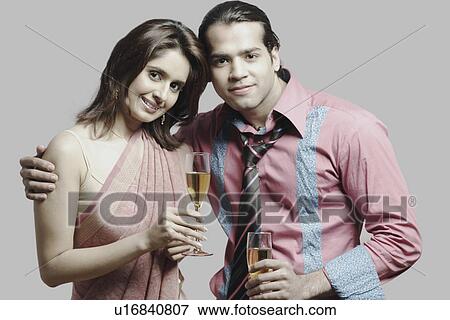 Portrait of a young couple holding champagne flutes View Large Photo Image Stock Photo - Portrait of a young couple holding champagne flutes. Fotosearch