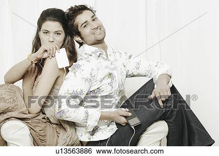 Portrait of a young couple listening to an MP3 players View Large Photo Image Stock Photograph - Portrait of a young couple listening to an MP3 players. Fotosearch
