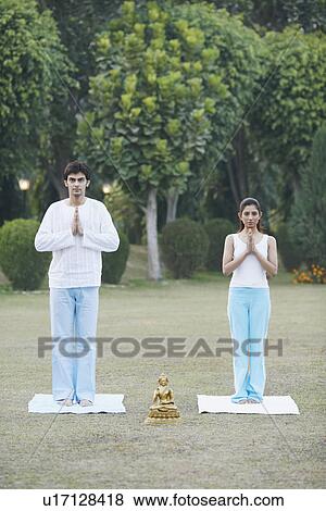 Stock Photo - Portrait of a young couple standing in a prayer position. Fotosearch
