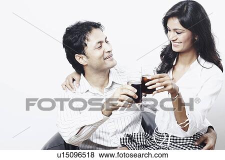 Young couple toasting with wine glasses View Large Photo Image Stock Photo - Young couple toasting with wine glasses. Fotosearch