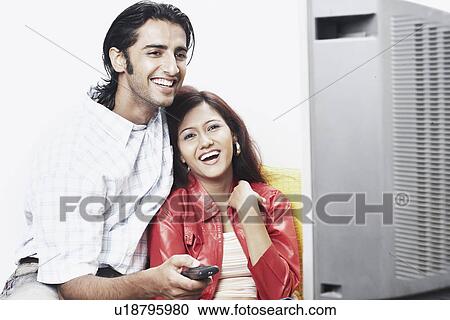 Stock Image - Young couple watching television. Fotosearch