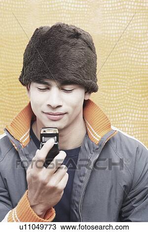 Close-up of a young man holding a mobile phone View Large Photo Image Stock Image - Close-up of a young man holding a mobile phone. Fotosearch