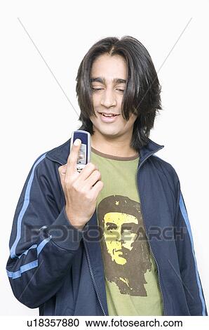 Close-up of a young man holding a mobile phone View Large Photo Image Stock Image - Close-up of a young man holding a mobile phone. Fotosearch
