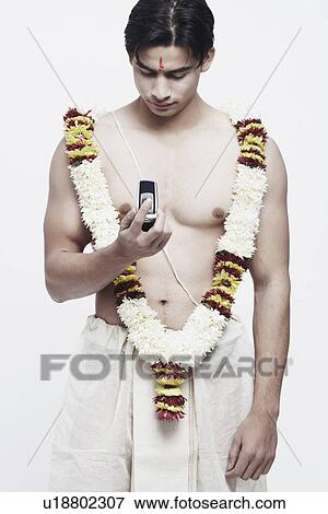 Stock Photo - Close-up of a young man holding a mobile phone. Fotosearch