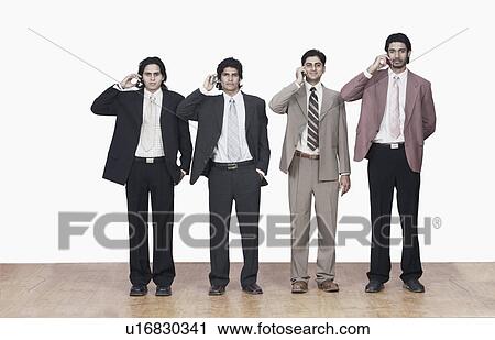 Stock Image - Four businessmen talking on mobile phones. Fotosearch
