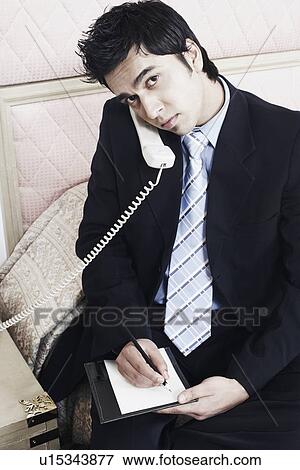 Stock Photo - Portrait of a businessman talking on the telephone. Fotosearch
