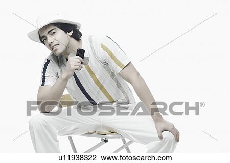 Portrait of a young man holding a mobile phone View Large Photo Image Stock Image - Portrait of a young man holding a mobile phone. Fotosearch