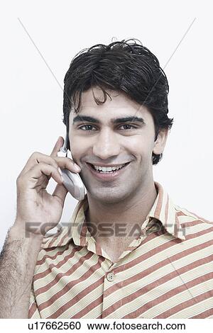 Portrait of a young man talking on a mobile phone View Large Photo Image Stock Image - Portrait of a young man talking on a mobile phone. Fotosearch