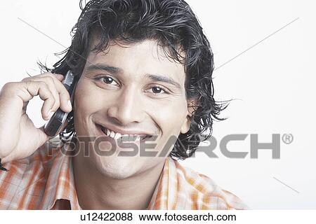 Portrait of a young man talking on a mobile phone View Large Photo Image Stock Photo - Portrait of a young man talking on a mobile phone. Fotosearch