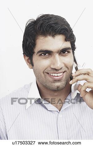 Portrait of a young man talking on a mobile phone View Large Photo Image Stock Photo - Portrait of a young man talking on a mobile phone. Fotosearch
