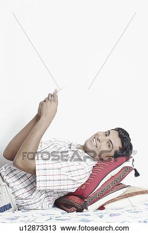 Side profile of a young man holding a mobile phone View Large Photo Image Stock Image - Side profile of a young man holding a mobile phone. Fotosearch