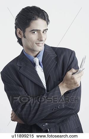 Young man holding a mobile phone View Large Photo Image Stock Photography - Young man holding a mobile phone. Fotosearch