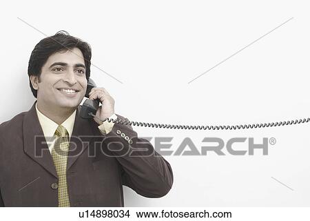 Businessman talking on the telephone View Large Photo Image Picture - Businessman talking on the telephone. Fotosearch