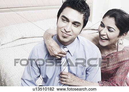 Close-up of a young woman adjusting a young man's tie View Large Photo Image Stock Image - Close-up of a young woman adjusting a young man's tie. Fotosearch
