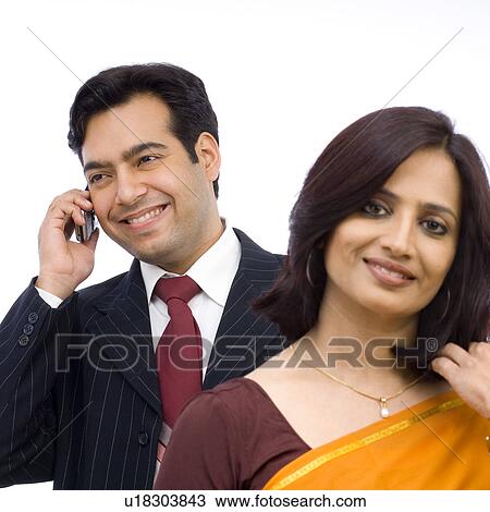 Stock Image - Mid adult woman standing in front of a young man. Fotosearch