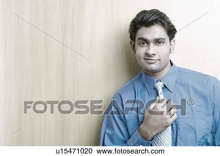 Portrait of a businessman adjusting his tie View Large Photo Image Stock Image - Portrait of a businessman adjusting his tie. Fotosearch