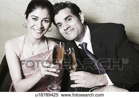 Stock Photography - Portrait of a businessman and a businesswoman holding champagne flutes. Fotosearch