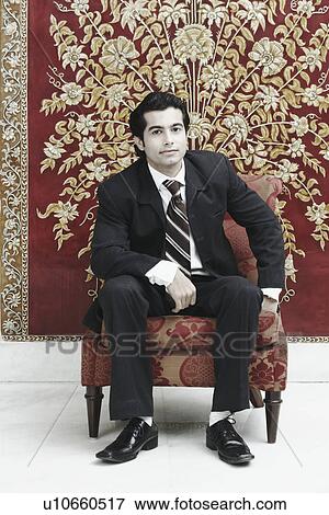 Stock Photo - Portrait of a businessman sitting on a chair. Fotosearch