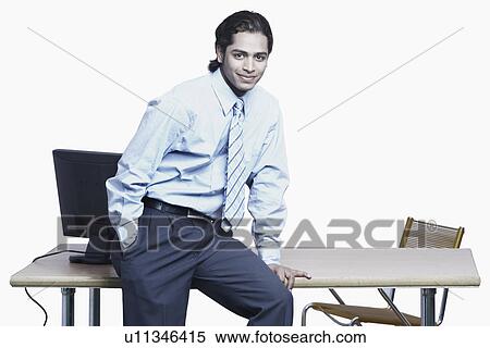 Stock Photography - Portrait of a businessman sitting on the table. Fotosearch