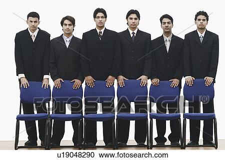 Portrait of a group of young men standing behind chairs View Large Photo Image Stock Image - Portrait of a group of young men standing behind chairs. Fotosearch