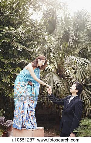 Stock Photo - Young man holding a young woman's hand. Fotosearch