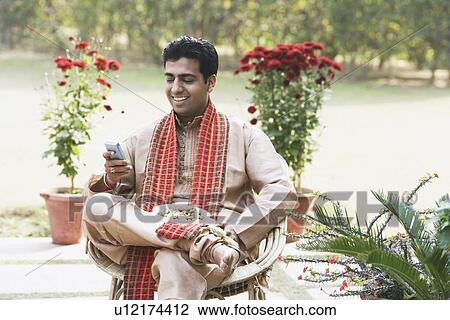 Close-up of a young man operating a mobile phone View Large Photo Image Stock Image - Close-up of a young man operating a mobile phone. Fotosearch