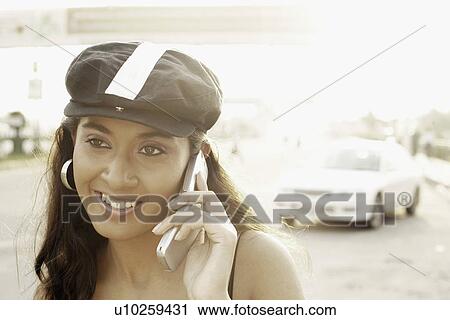 Close-up of a young woman talking on a mobile phone View Large Photo Image Stock Image - Close-up of a young woman talking on a mobile phone. Fotosearch