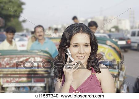 Close-up of a young woman talking on a mobile phone View Large Photo Image Stock Image - Close-up of a young woman talking on a mobile phone. Fotosearch