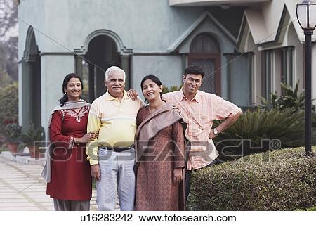 Portrait of a mature couple and their two children standing in front of a house View Large Photo Image Stock Image - Portrait of a mature couple and their two children standing in front of a house. Fotosearch