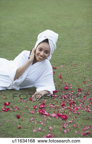 Portrait of a teenage girl in a bathrobe lying on the grass View Large Photo Image Stock Photo - Portrait of a teenage girl in a bathrobe lying on the grass. Fotosearch