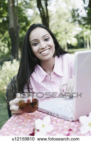 Stock Image - Portrait of a teenage girl using a laptop. Fotosearch