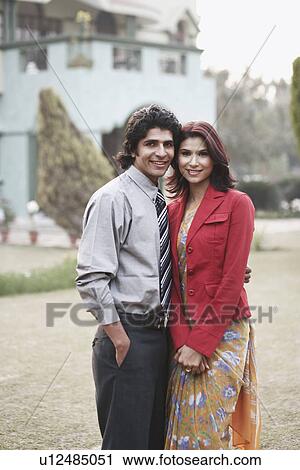 Portrait of a young couple standing in the garden View Large Photo Image Stock Image - Portrait of a young couple standing in the garden. Fotosearch