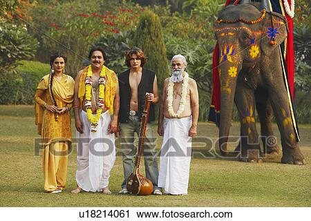 Stock Image - Portrait of four people standing together in the park. Fotosearch