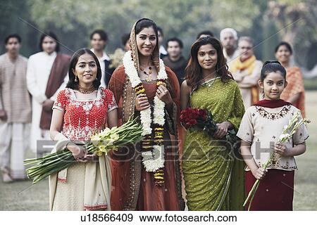 Stock Photo - Portrait of three sisters smiling with a bride. Fotosearch