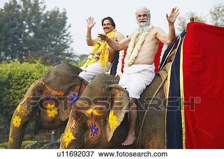 Stock Photo - Portrait of two priests riding elephants. Fotosearch