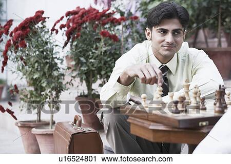 Stock Image - Two businessmen playing chess. Fotosearch