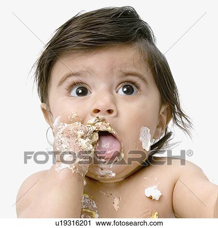 Stock Image - Close-up of a baby boy eating a birthday cake. Fotosearch