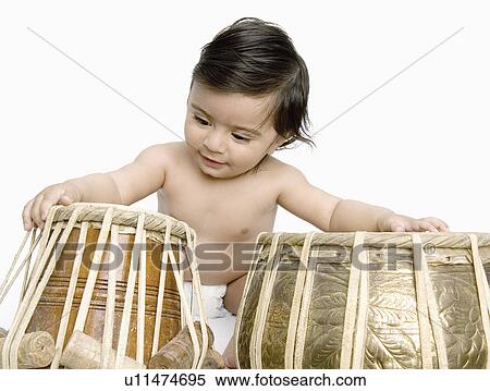Stock Photography - Close-up of a baby boy playing the tabla. Fotosearch