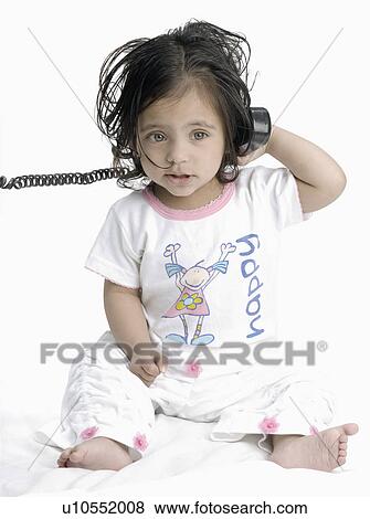 Close-up of a baby girl holding a telephone receiver View Large Photo Image Stock Photo - Close-up of a baby girl holding a telephone receiver. Fotosearch