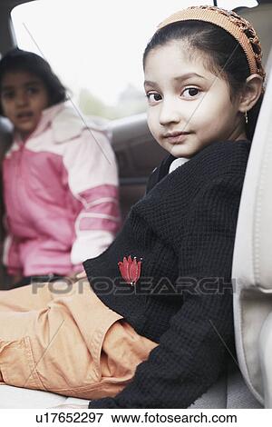 Close-up of a girl and her sister sitting in a car View Large Photo Image Stock Photo - Close-up of a girl and her sister sitting in a car. Fotosearch