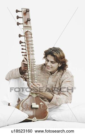 Stock Image - Close-up of a male musician playing the sitar. Fotosearch