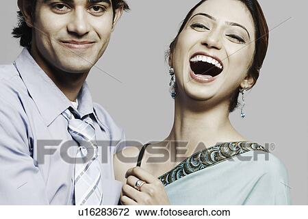 Stock Image - Close-up of a young woman and a young man laughing. Fotosearch