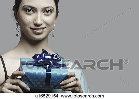Picture - Portrait of a young woman holding a gift. Fotosearch