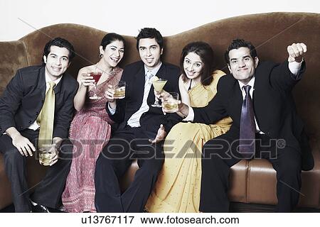 Stock Photo - Portrait of three young women and two young men holding glasses. Fotosearch