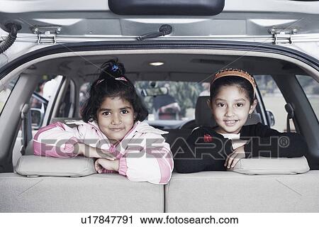 Stock Image - Portrait of two girls sitting in a car. Fotosearch