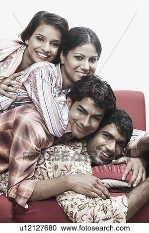 Portrait of two young men and two young women lying on top of each other smiling View Large Photo Image Stock Image - Portrait of two young men and two young women lying on top of each other smiling. Fotosearch