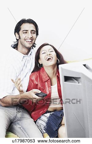 Young couple watching television View Large Photo Image Stock Image - Young couple watching television. Fotosearch
