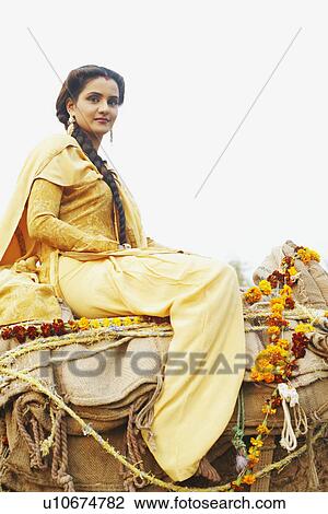 Low angle view of a young woman riding a camel View Large Photo Image Stock Image - Low angle view of a young woman riding a camel. Fotosearch